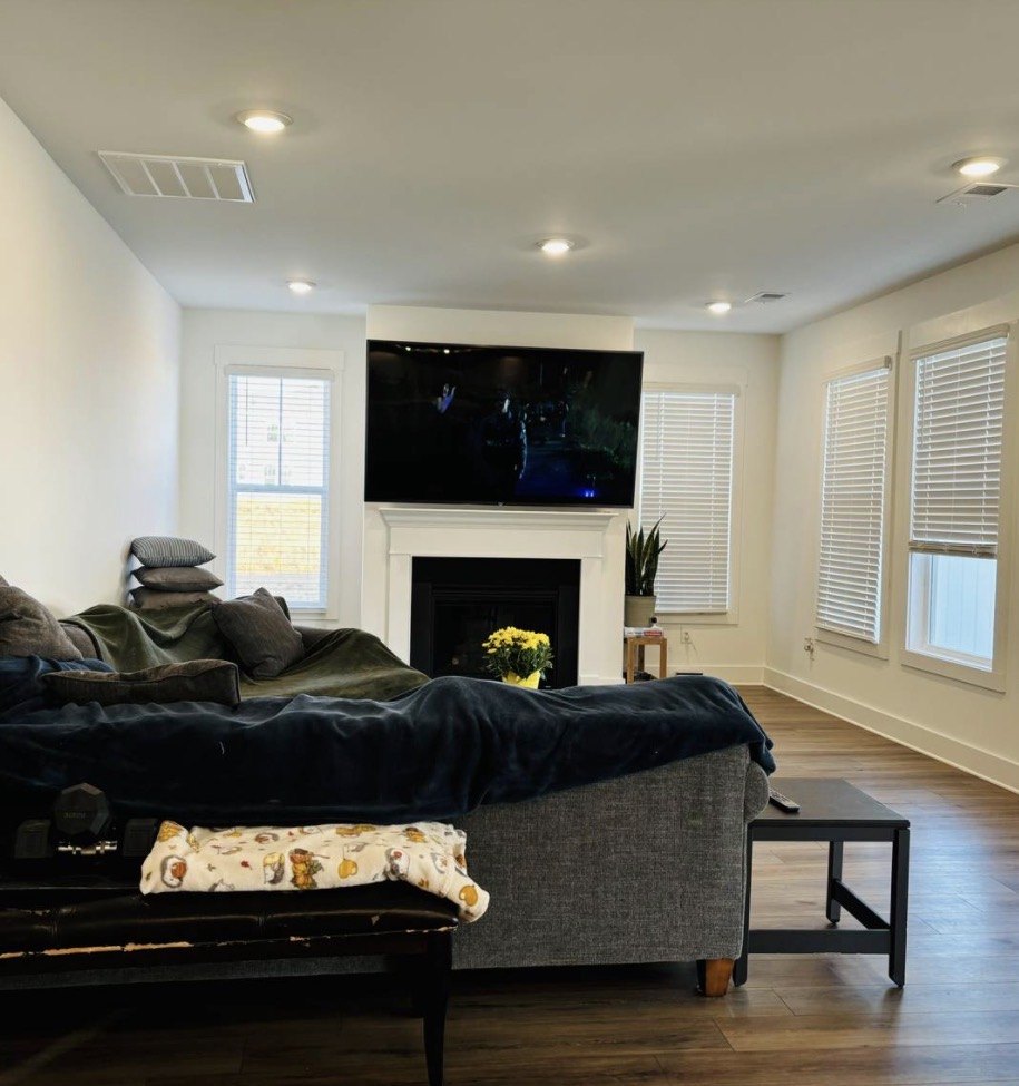 Bright living room with a couch, fireplace, and TV